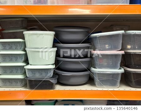 Plastic storage containers on a shelf in a store. Plastic storage containers on a shelf in a store. 135640146