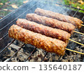Grilled kebabs on skewers over charcoal on a barbecue grill. 135640187