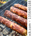 Juicy grilled kebabs sizzling on a charcoal barbeque. 135640188