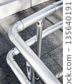 Stainless steel handrail on urban sidewalk. 135640191