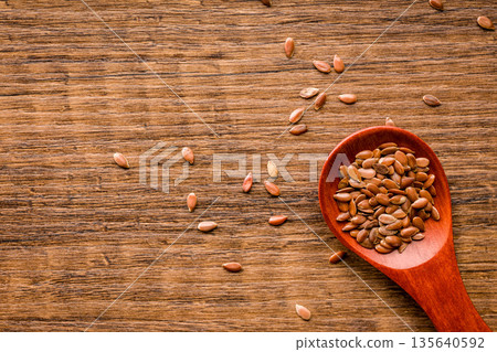 Brown linseed or flaxseed . Healthy flax seed on wooden spoon on wooden table. Top view. 135640592