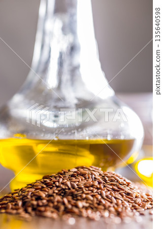 Brown linseed or flaxseed and oil. Healthy flax seed on wooden table. 135640598