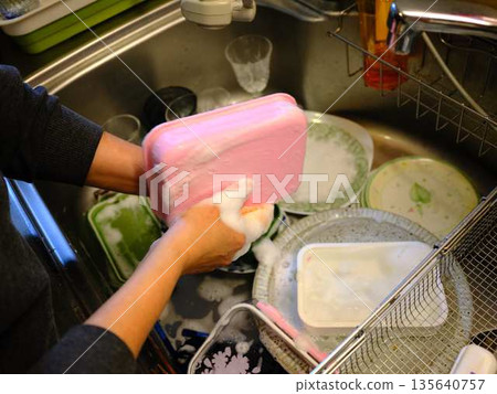 Hands of a woman washing dishes 135640757