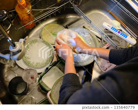 Hands of a woman washing dishes 135640779