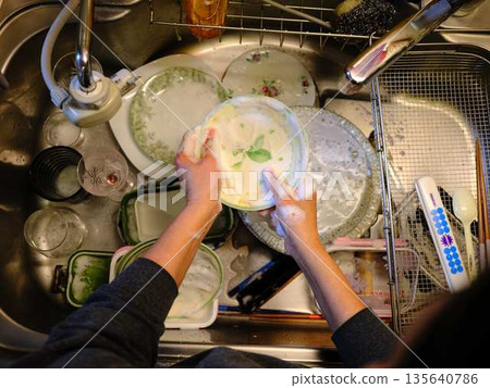 Hands of a woman washing dishes 135640786