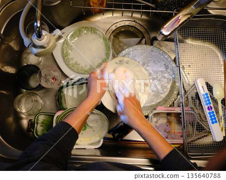 Hands of a woman washing dishes Hands of a woman washing dishes 135640788
