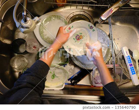 Hands of a woman washing dishes Hands of a woman washing dishes 135640790