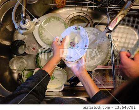 Hands of a woman washing dishes Hands of a woman washing dishes 135640791