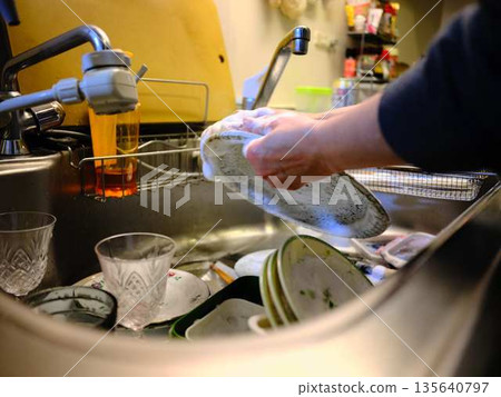 Hands of a woman washing dishes Hands of a woman washing dishes 135640797