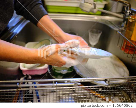 Hands of a woman washing dishes 135640802