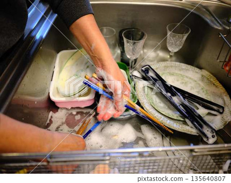 Hands of a woman washing dishes Hands of a woman washing dishes 135640807