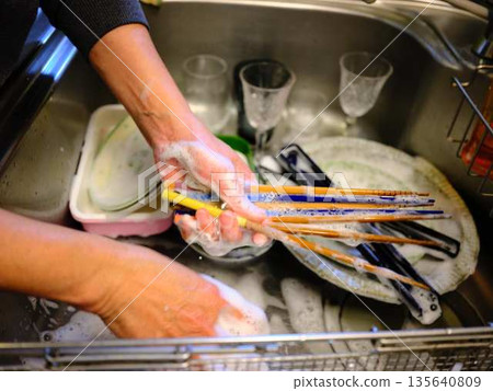 Hands of a woman washing dishes Hands of a woman washing dishes 135640809