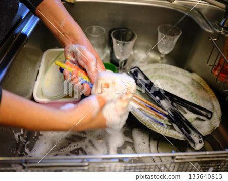 Hands of a woman washing dishes Hands of a woman washing dishes 135640813