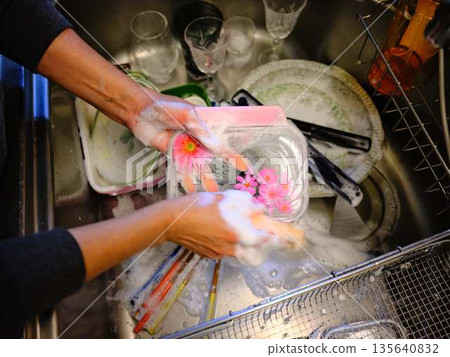 Hands of a woman washing dishes Hands of a woman washing dishes 135640832