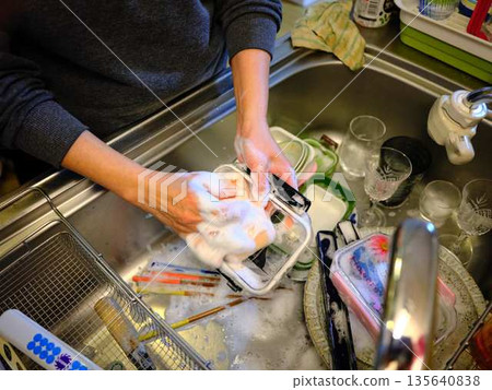 Hands of a woman washing dishes Hands of a woman washing dishes 135640838