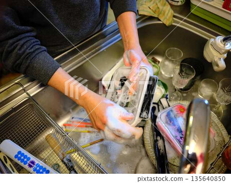 Hands of a woman washing dishes Hands of a woman washing dishes 135640850
