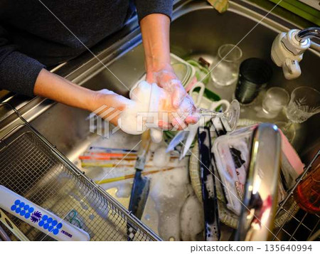 Hands of a woman washing dishes Hands of a woman washing dishes 135640994
