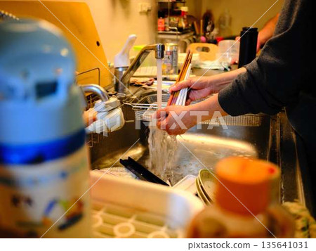 Hands of a woman washing dishes Hands of a woman washing dishes 135641031