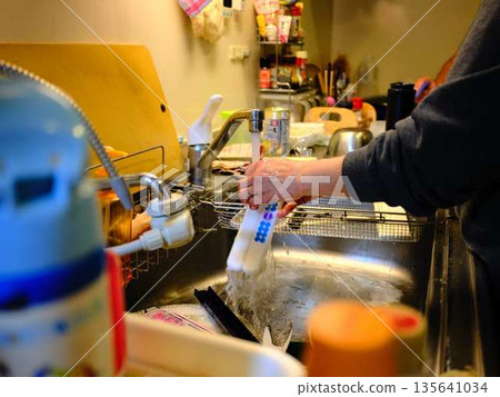 Hands of a woman washing dishes Hands of a woman washing dishes 135641034