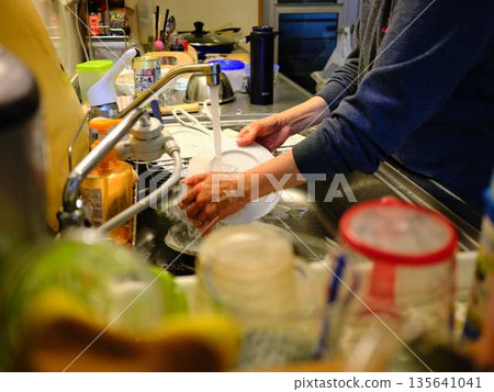 Hands of a woman washing dishes Hands of a woman washing dishes 135641041