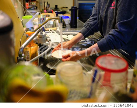 Hands of a woman washing dishes Hands of a woman washing dishes 135641042
