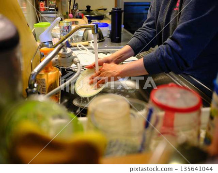 Hands of a woman washing dishes Hands of a woman washing dishes 135641044