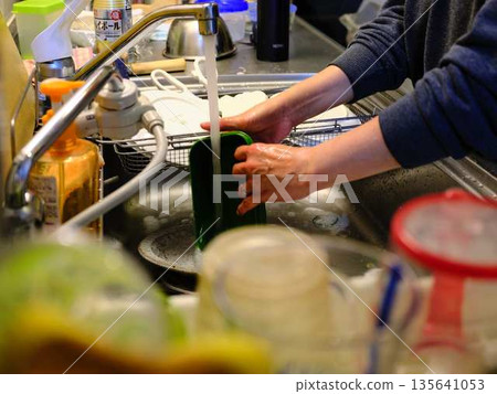 Hands of a woman washing dishes Hands of a woman washing dishes 135641053