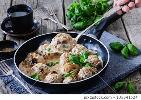 Chicken meatball on spoon over pan with sauce Chicken meatball on spoon over pan with sauce 135641524