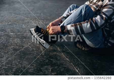 Wearing his skates. A man is on the ice in winter Wearing his skates. A man is on the ice in winter 135642260