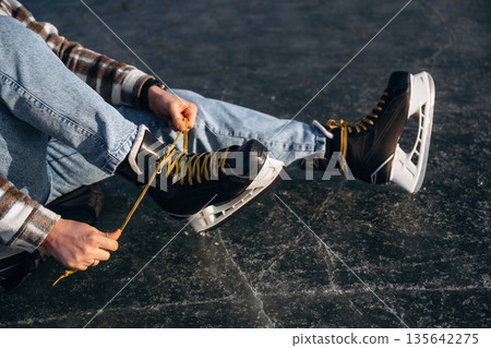 Side close up view, wearing skates. A man is on the ice in winter Side close up view, wearing skates. A man is on the ice in winter 135642275