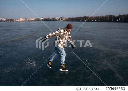 Weekend activity. A man is on the ice with his skates in winter 135642280