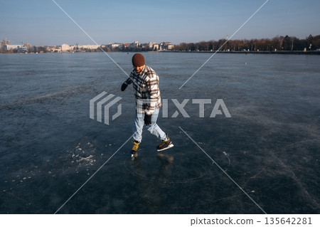 Weekend activity. A man is on the ice with his skates in winter 135642281