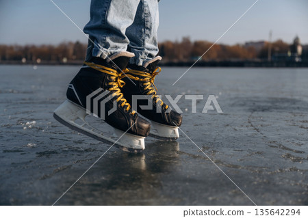 On the surface. Close up view of man that is on ice with skates in winter 135642294