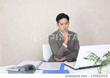 Businessman doing desk work Businessman doing desk work 135642419