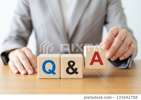 Wooden blocks representing Q&A and the hands of a female businesswoman 135642788