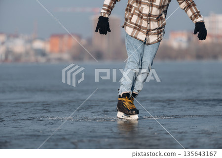Daytime leisure activity. Close up view of man that is on ice with skates in winter 135643167
