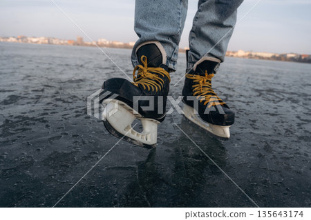 Showing sharp blade. Close up view of man that is on ice with skates in winter 135643174