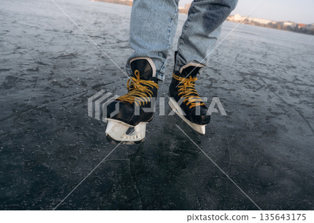 Showing sharp blade. Close up view of man that is on ice with skates in winter 135643175