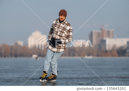 Having fun by riding. A man is on the ice with his skates in winter Having fun by riding. A man is on the ice with his skates in winter 135643201