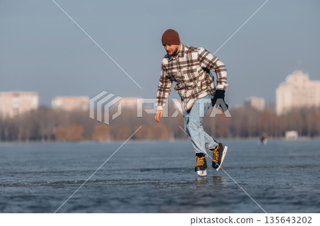 Having fun by riding. A man is on the ice with his skates in winter Having fun by riding. A man is on the ice with his skates in winter 135643202