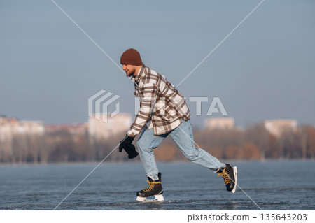 In motion, riding. A man is on the ice with his skates in winter In motion, riding. A man is on the ice with his skates in winter 135643203