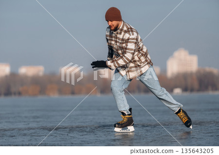 In motion, riding. A man is on the ice with his skates in winter In motion, riding. A man is on the ice with his skates in winter 135643205