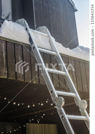 Winter Maintenance: Ladder Ready for Balcony Snow Removal. Winter Maintenance: Ladder Ready for Balcony Snow Removal. 135643354