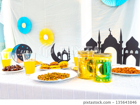 Eid Mubarak table with Ramadan sweets, dates, nuts and festive decor Eid Mubarak table with Ramadan sweets, dates, nuts and festive decor 135643846
