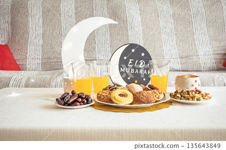Eid Mubarak table with Ramadan sweets, dates, nuts and festive decor Eid Mubarak table with Ramadan sweets, dates, nuts and festive decor 135643849