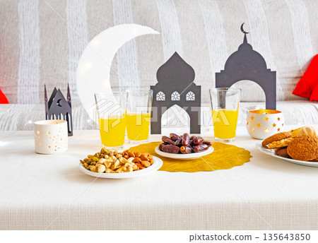Eid Mubarak table with Ramadan sweets, dates, nuts and festive decor Eid Mubarak table with Ramadan sweets, dates, nuts and festive decor 135643850