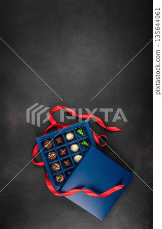 Luxury chocolate gift box with red ribbon on dark background Luxury chocolate gift box with red ribbon on dark background 135644961