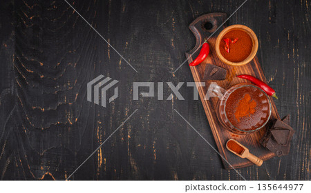 Spicy hot chocolate with chili and dark chocolate on rustic wooden background 135644977