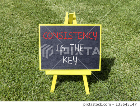 Consistency is the key symbol. Concept words Consistency is the key on beautiful blackboard. Beautiful green grass lawn background. Business consistency is the key concept. Copy space. Consistency is the key symbol. Concept words Consistency is the key on beautiful blackboard. Beautiful green grass lawn background. Business consistency is the key concept. Copy space. 135645147