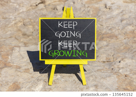Keep going and growing symbol. Concept words phrase Keep going keep growing on beautiful black blackboard. Beautiful stone background. Business Keep going and growing concept. Copy space. 135645152